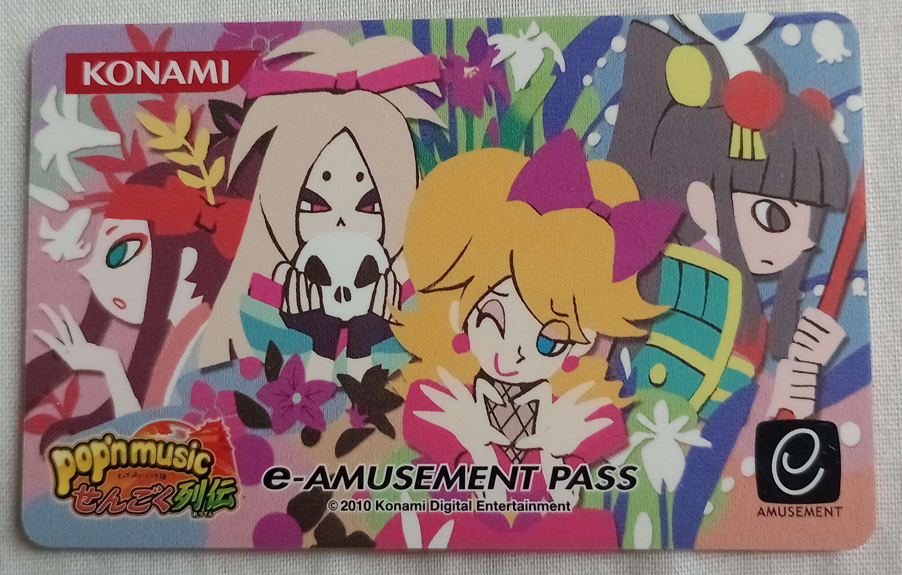 TROUT's e-amusement card. It has a design of four pop'n music characters on it.
